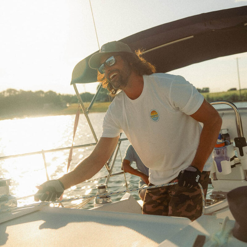Man enjoying a sunny boat ride wearing Olabrasa OG T-Shirt