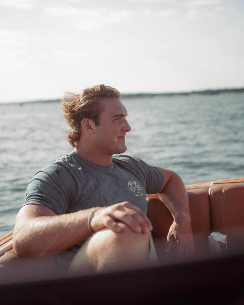 Man relaxing on a boat wearing Olabrasa Paddle T-Shirt