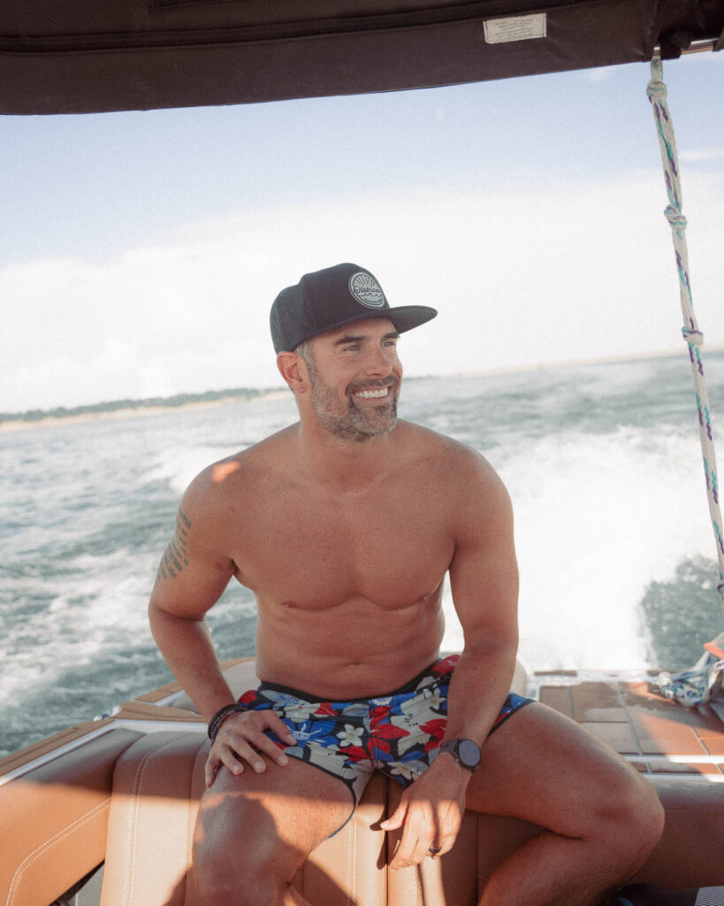 Man on boat wearing the Black Olabrasa OG Flat SnapBack enjoying a day on the lake.